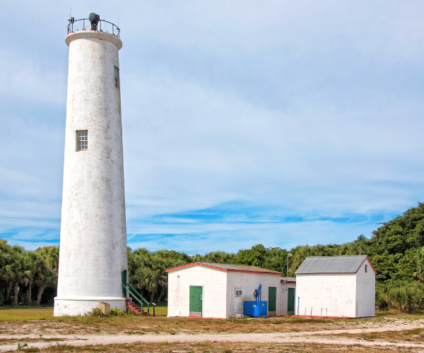 Large white Lighthouse and buildings at Egmont Key Florida